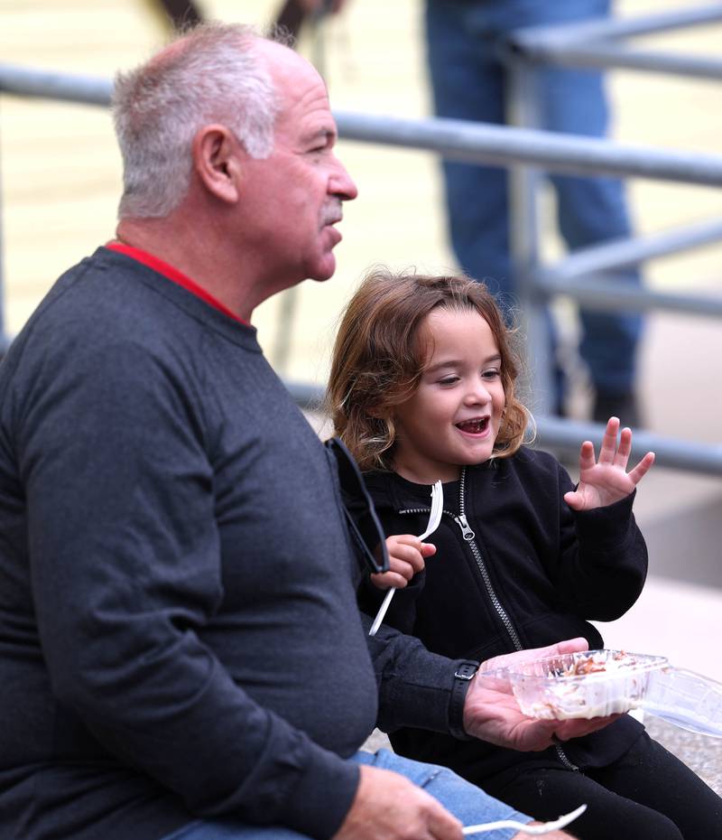 Holly Roach, 3, from Millington, enjoys her cinnamon roll with her grandpa Ed Mosca, from Sandwich, Wednesday, Sept. 3, 2025, following the opening ceremony at the Sandwich Fair.