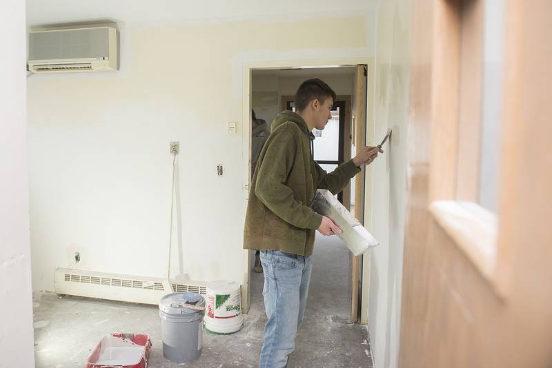 Donald Schofield of Rock Falls High School works on the drywall of a break room at the Regional Office of Education with other members of his building trades class.