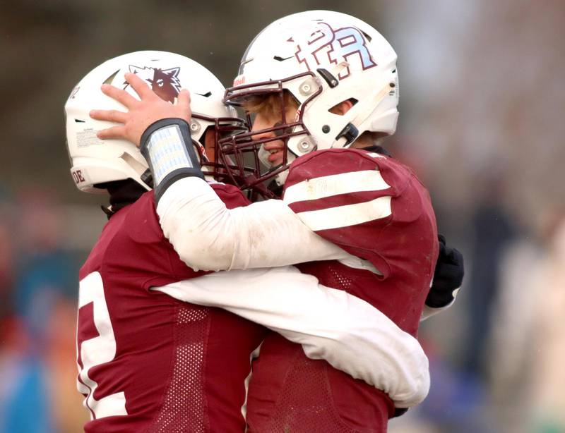 Prairie Ridge’s Tyler Vasey, right, embraces teammate Brogan Amherdt after Amherdt’s field goal clinched a win over St. Ignatius in Class 6A football playoff semifinal action at Crystal Lake on Saturday.