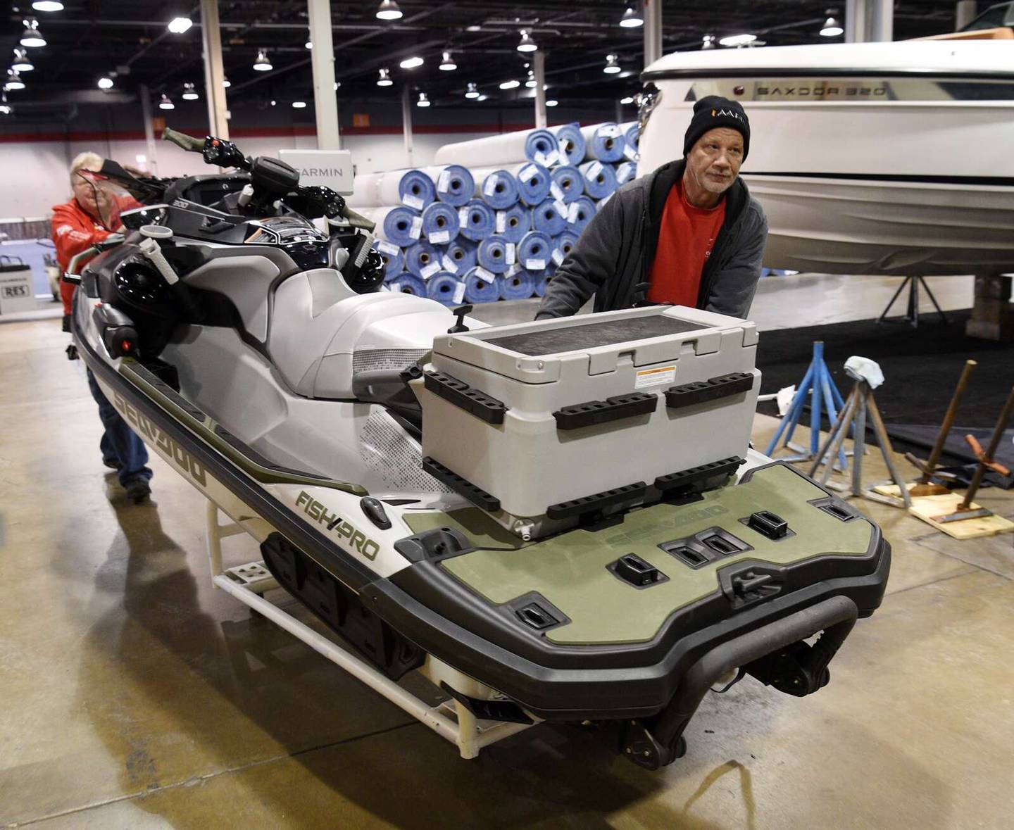 Steve Wegrzyn, from right, and Al Jurkutat move a personal watercraft into position during setup for the Chicago Boat Show at the Donald E. Stephens Convention Center in Rosemont on Tuesday.