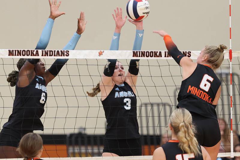 Joliet Catholic’s Brooke Simon gets a hand on the shot by Minooka’s Kendall Kozak on Wednesday, Sept. 4, 2024 in Minooka.