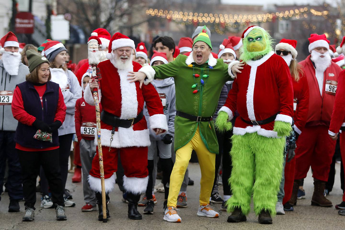 Chris Christensen, dressed as Buddy the Elf, jokingly separates Santa Claus and Russ Hyatt of Sundowner Entertainment, dressed as the Grinch before the start of the McHenry County Santa Run For Kids on Sunday morning, Dec. 3, 2023, in Downtown Crystal Lake. The annual event raises money for agencies in our county who work with children in need.
