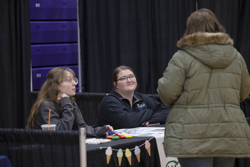 Katie Asumendi (left) and Emma Beardsley, representatives of Woodhaven Lakes, speak with a visitor Wednesday, March 11, 2026, at Discover Dixon’s career fair. Held at Dixon High School, the fair welcomed in students before it was opened to the general public.