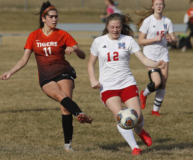 Crystal Lake Central's Kaitlin Gaunaurd takes a shot on goal as she is defended by Marian Central's Abbey Miner during a non-conference soccer match Monday, March 21, 2022, between Crystal Lake Central and Marian Central at Crystal Lake Central High School.