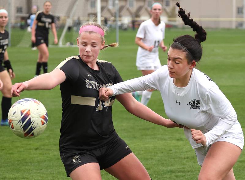 Sycamore's Peyton Wright (left) and Kaneland's Alexandra Warrington try to win possession of a throw in during their game Wednesday, April 17, 2024, at Sycamore High School.
