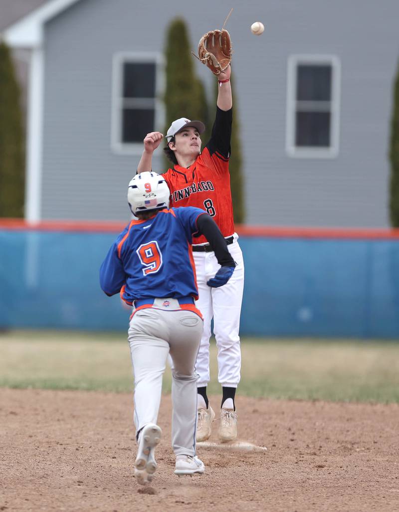 Genoa-Kingston's Brycen Lavender tries to beat out a high throw from the outfield but Winnebago's Alec Weavel is able to come down with it for a force-out during their game Tuesday, April 12, 2022, at Genoa-Kingston High School.