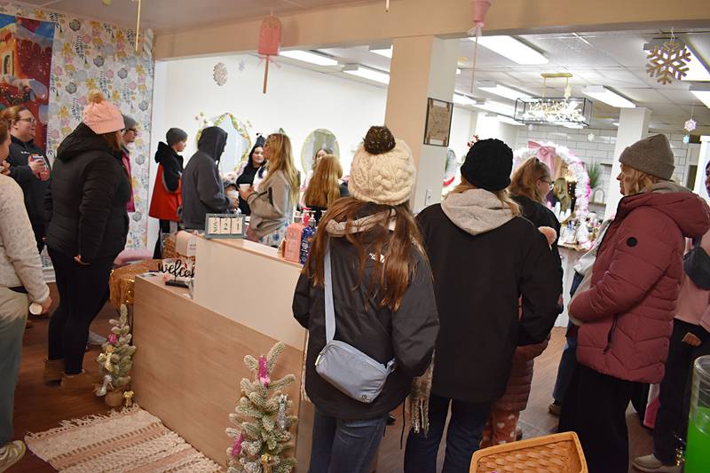 A crowd of people visit a downtown business to drink hot chocolate and visit the Grinch in Rock Falls Friday, Nov. 21, 2025.