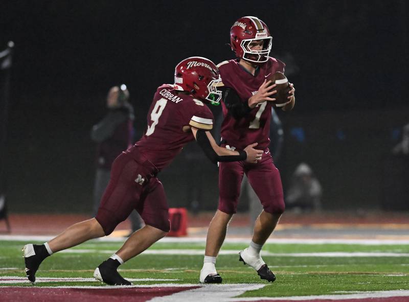 Morris' Brady Varner (7) hands the ball off to Caeden Curran (9) during the class 4A first round playoff game against Woodstock on Friday, OCT. 31, 2025, at Morris.