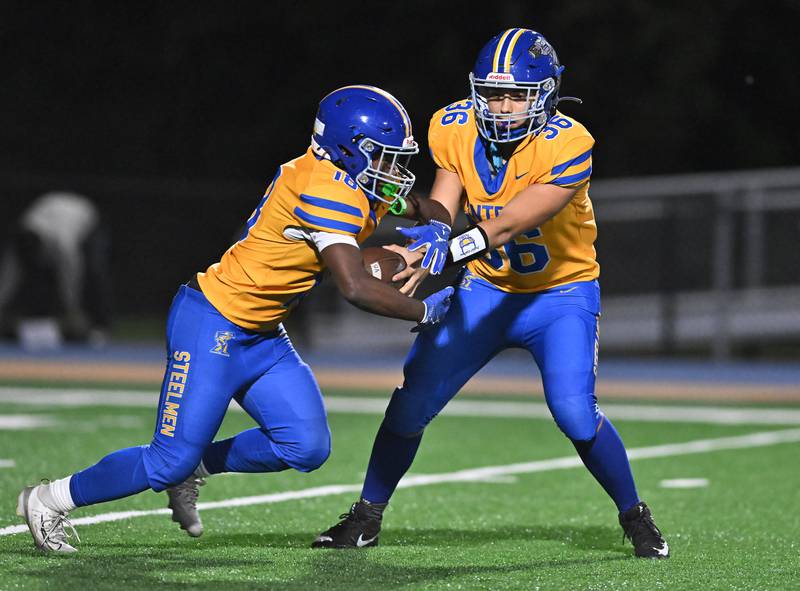 Joliet Central's Jeffrey Grimes (36) hands the ball of to Tristen Sellers during the conference game against Plainfield South on Friday, OCT. 17, 2025, at Joliet.