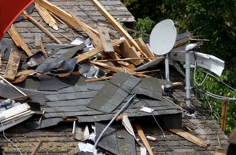 Debris on the neighbors home as authorities look for the cause of a home explosion on Monday, May 18, 2026, in 7400 block of Birch Drive, in Wonder Lake, after the Sunday evening explosion. One resident of a home was killed and two others have been taken to the hospital.