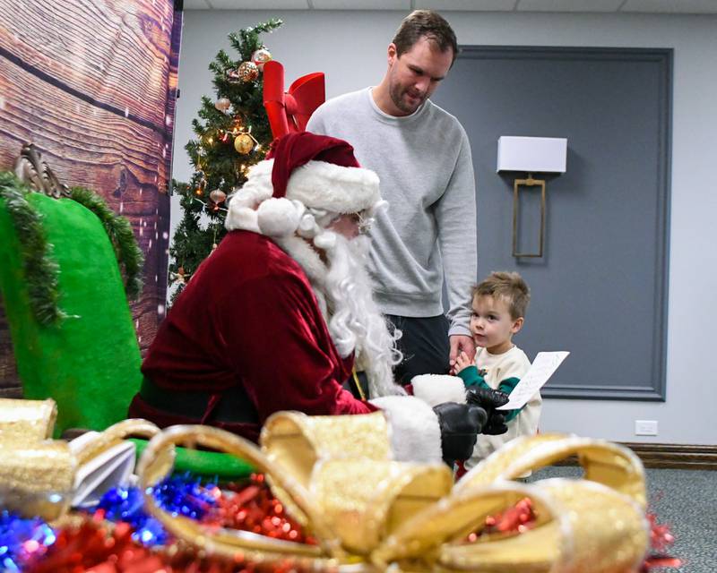 Tom Cronin and his son Charlie Cronin, 3, of La Grange Park talk with Santa and goes over Charlie’s Christmas list during the breakfast with Santa event on Sunday Dec. 15, 2024, held at the La Grange Park District Recreation Center.