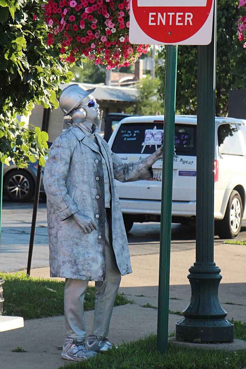 A performer dressed as a statue from Matthew McMunn Entertainment works the streets Saturday, August 12, 2023 during Venetian Night in Dixon.