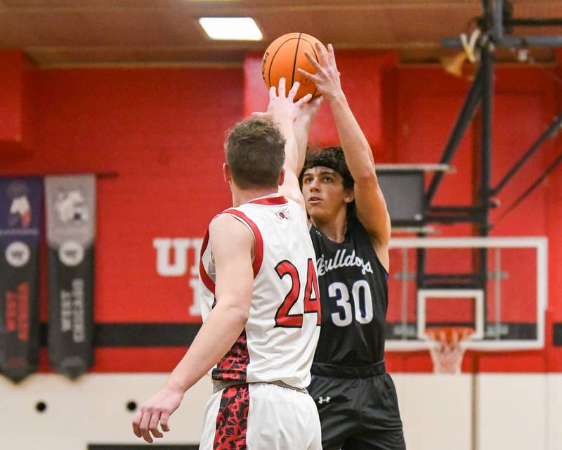 Riverside Brookfield's Liam Enright (30) makes a basket while being defended by Glenbard East's Sam Walton (24) during the game on Friday Dec. 19, 2025, held at Glenbard East High School.