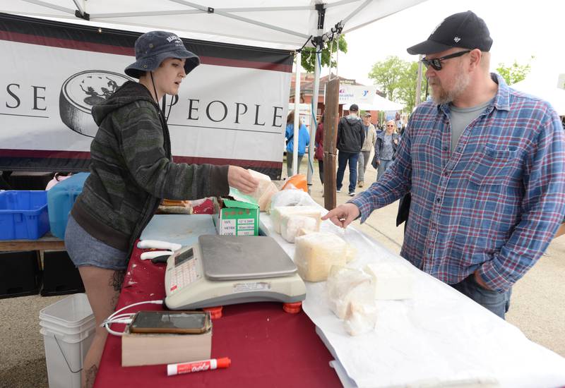 Downers Grove Farmers Market vendor Ava Miller of Chicago offers a variety of cheese to potential customers including Vitas Zebraitis of Downers Grove Saturday May 13, 2023.