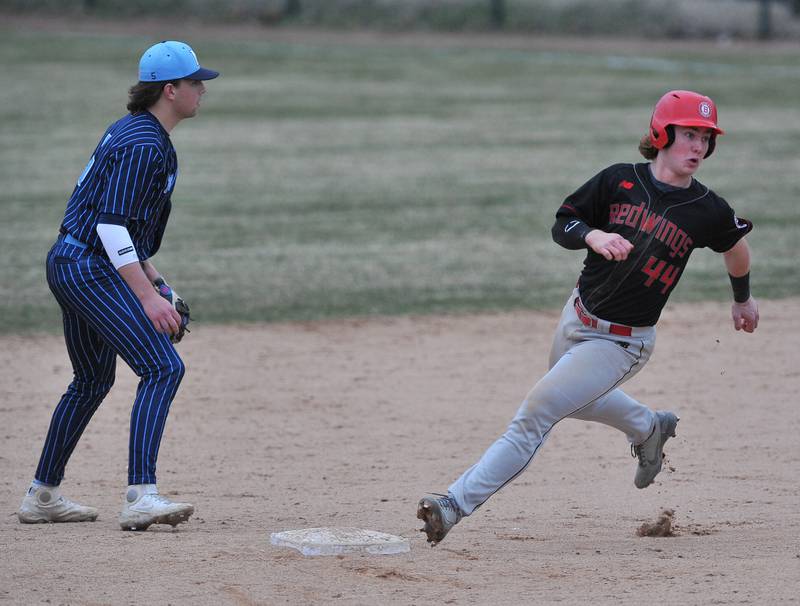 Benet's Jackson Bayer (44) rounds second base on a hit and run play as Nazareth shortstop watches the play at first during a game on Apr. 12, 2022 at Nazareth Academy in LaGrange Park.