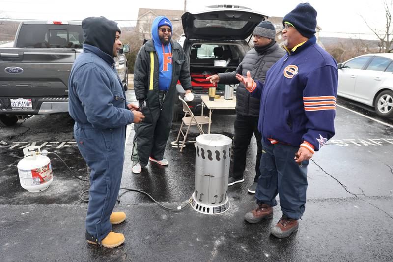 East St. Louis fans Kyle Tuyson, left, Chuck Wood, Berry Tyler and Henry Smith tailgate before the game against against Lemont in the Class 6A semifinal. Wood played center for the 1983 State Champion East St. Louis team.