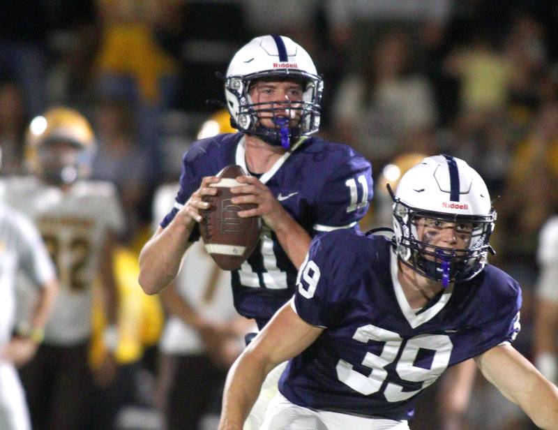 Cary-Grove’s Peyton Seaburg looks for an option as Holden Boone protects him against Jacobs in varsity football on Friday, Sept. 20, 2024, at Al Bohrer Field on the campus of Cary-Grove High School in Cary.
