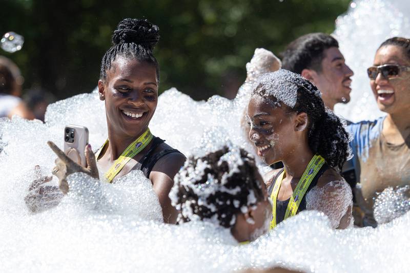 (left to right) Janasha Eakins and Milan Eakins play in bubbles at finish line of the 2025 Muddy Dash on Saturday, June 28, 2025 at Fox Valley Off Road in Utica.