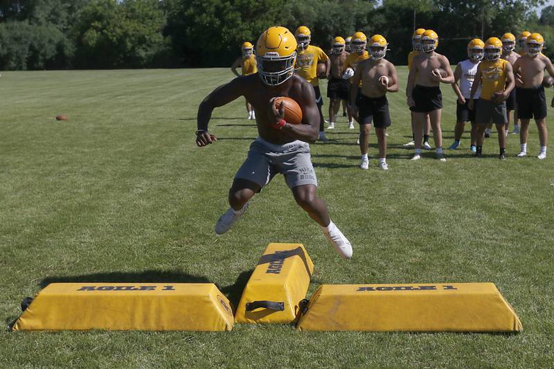 Running back Antonio Brown jumps as he does a running drill during football practice Monday, June 20, 2022, at Jacobs High School in Algonquin.