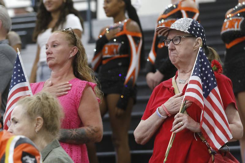 People listen to the National Athen as veterans returning from the McHenry County Honor Flight trip to Washington D.C., are celebrated on Sunday, Aug. 27, 2023, at McHenry Community High School’s Upper Campus.