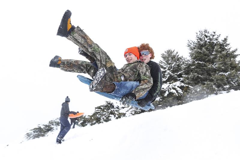 Todd Griswold (left) and Jaiden Gershon (right) fly off a sledding jump on Sunday, Jan. 31, 2021, at Cene's Four Seasons Park in Shorewood, Ill. Nearly a foot of snow covered Will County overnight, resulting in fun for some and challenges for others.