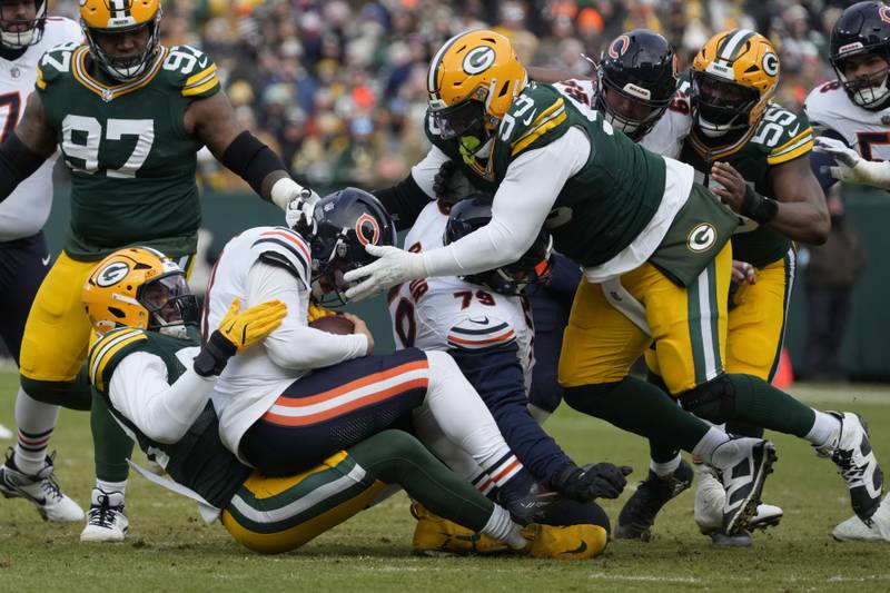 Green Bay Packers defensive end Rashan Gary, bottom left, tackles Chicago Bears quarterback Caleb Williams, middle left, during the first half of an NFL football game, Sunday, Jan. 5, 2025, in Green Bay, Wis. (AP Photo/Morry Gash)
