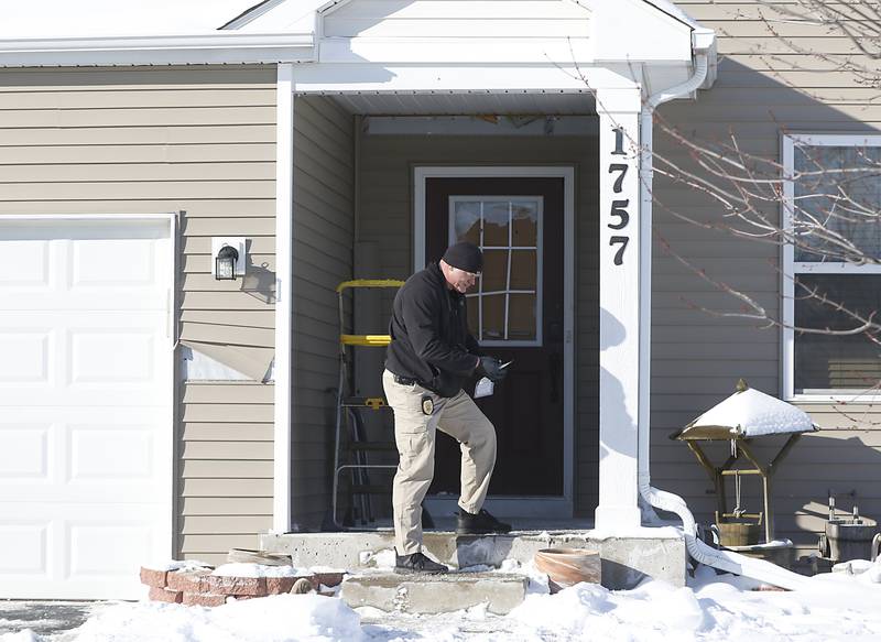 Woodstock Police Officer Josh Fourdyce collects evidence the morning of Tuesday, Jan. 25, 2022, after a shooting Monday evening, outside the in the home in the 1700 block of Yasgur Drive in Woodstock.