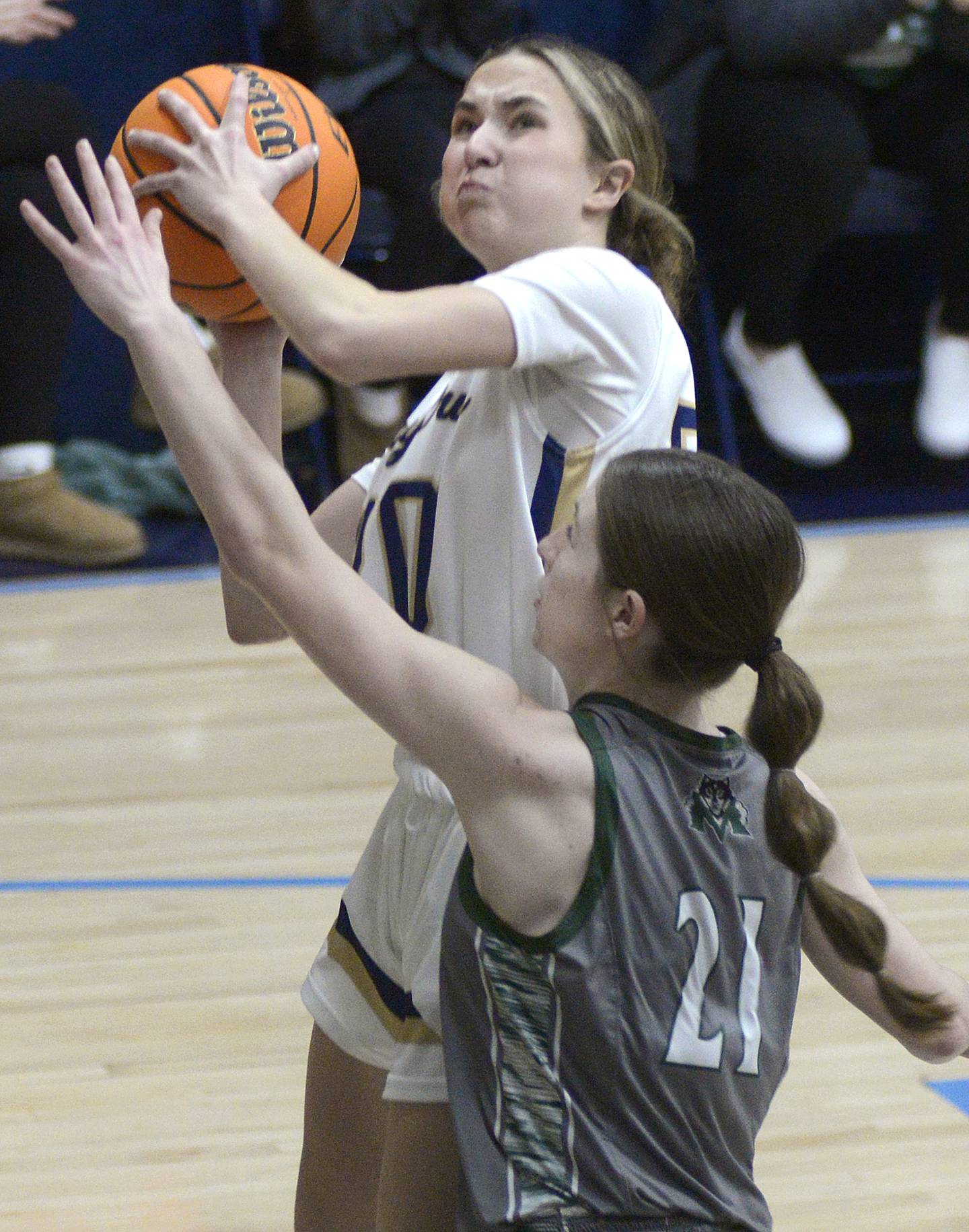 Marquette’s Kaitlyn Davis works to shoot past the block of Midland’s Adalynn Stickel in the first period Thursday at Marquette.