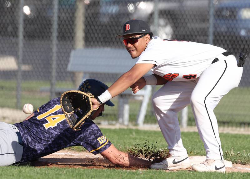 Neuqua Valley's Daniel Marketti slides back safely into first as DeKalb's Maddux Clarence makes the catch on a pickoff attempt during their game Tuesday, May 7, 2024, at DeKalb High School.