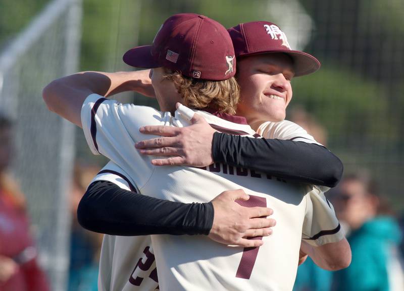 Prairie Ridge’s Trace Vrbancic is embraced by teammate Teddy Burseth after a win over Woodstock North in Class 3A Regional baseball action at Cary Thursday.
