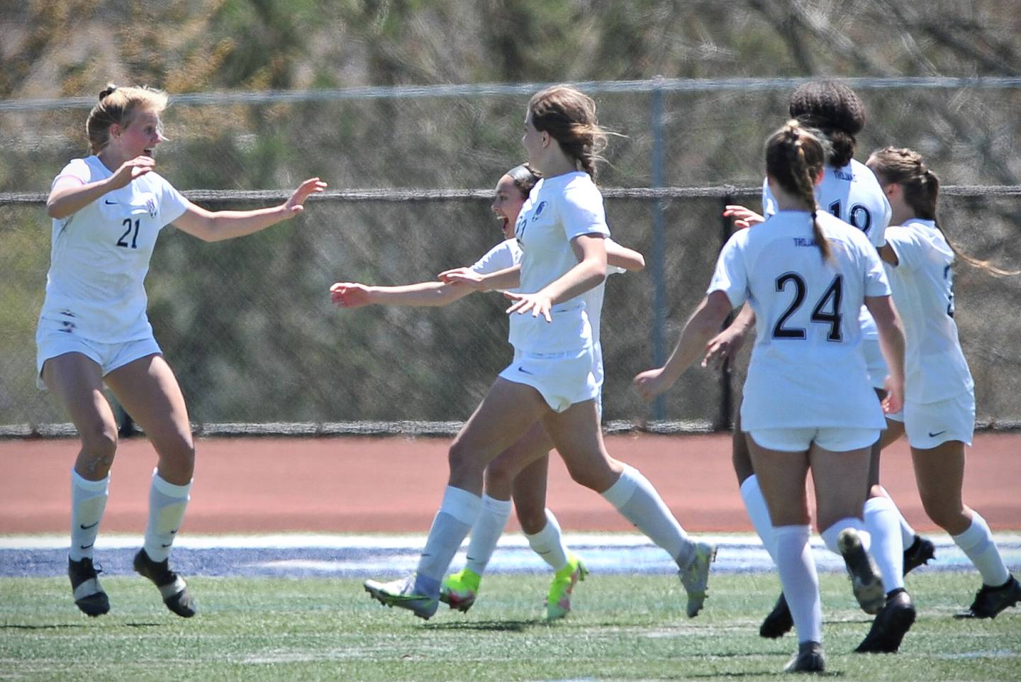 Ryann Wendt (21) is rushed by Downers Grove North teammates after scoring a goal against Downers Grove South during a game on May. 7, 2022 at Downers Grove South High School.