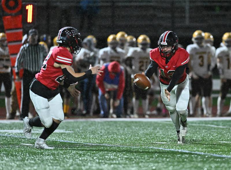 Lincoln-Way Central's Michael Kuehl tosses the ball to Anthony Noto  during the class 7A first round  playoff game on Friday, Oct. 27, 2023, at New Lenox. (Dean Reid for Shaw Local News Network)