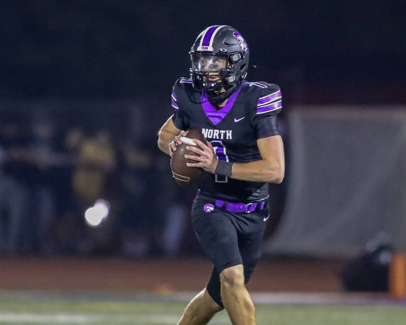 Downers Grove North's Damien Green (1) rolls out during football game between York at Downers Grove North.  Sept 29, 2023.