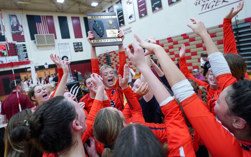 Oswego’s Riley Borrowman (3) raises the 4A regional championship plaque in celebration of Oswego’s victory over Plainfield North in their class 4A regional volleyball final at Plainfield North High School on Thursday, Oct. 26, 2023.