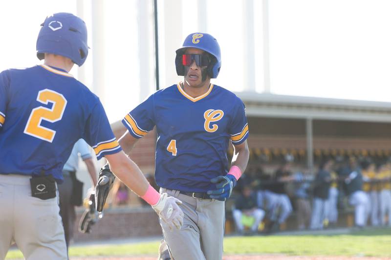 Joliet Central’s Andrew Nixon is greeted by his teammate after scoring on a wild throw against Joliet West on Monday, April 15, 2024.