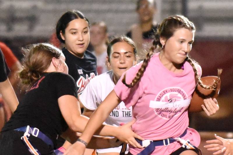 Bradley-Bourbonnais' Shannon Lee, right, runs through the defense during the first day of girls flag football practice Monday, Aug. 11, 2025.