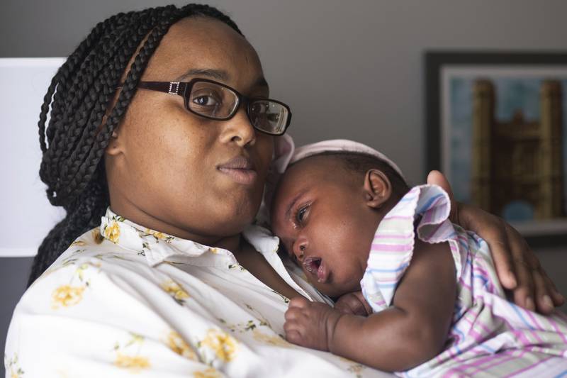 Asian Davis, 33, of Sikeston, Mo., cradles her 8-month-old daughter Mira White during an interview on Oct. 3, 2023, in St. Louis. Davis and her lawyers say Mira suffered brain damage in March after developing bacterial meningitis tied to powdered infant formula contaminated with Cronobacter sakazakii, a germ known to cause severe disease in young babies.