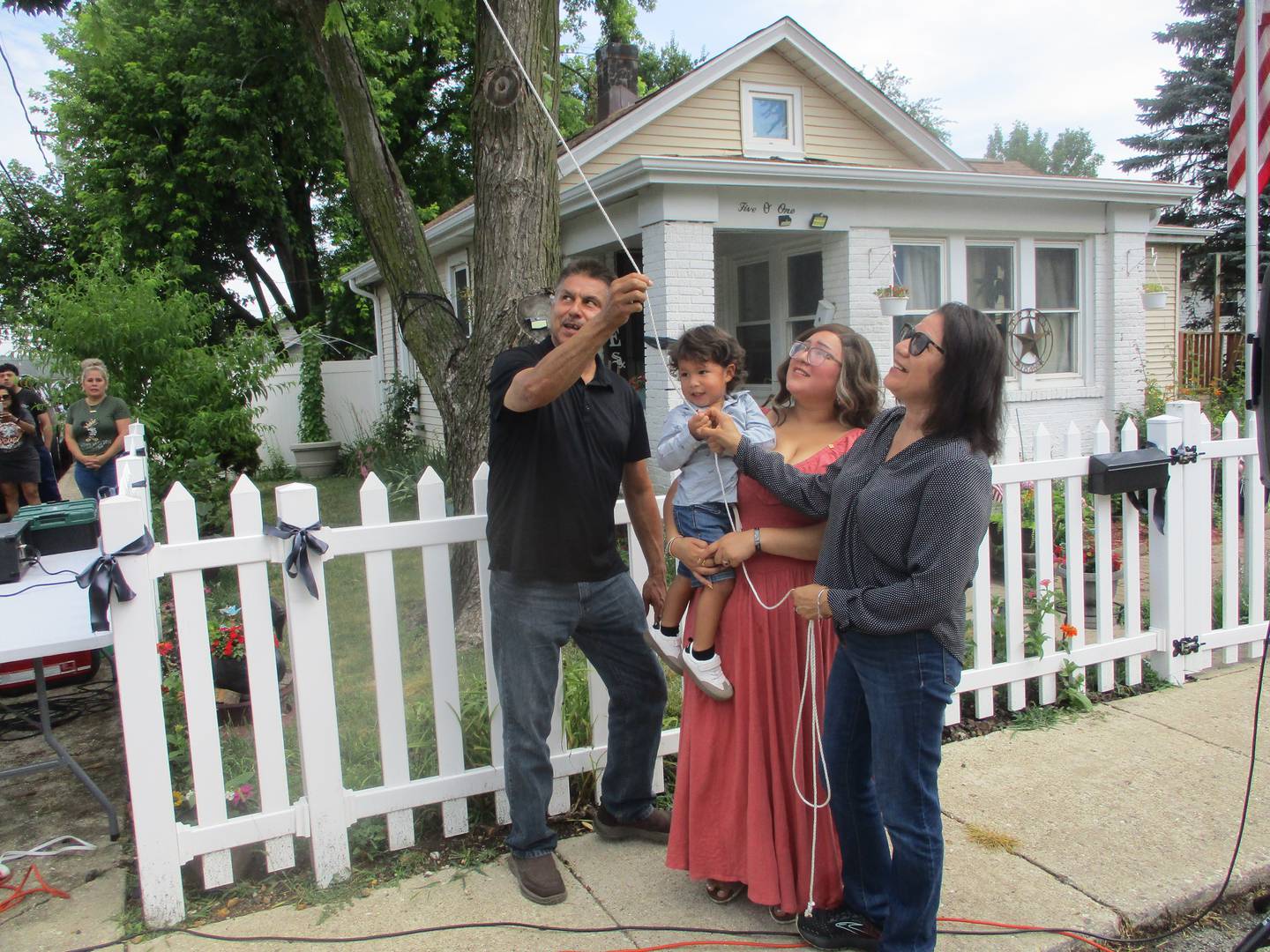 Jose Duenez Jr.'s parents, Jose Duenez Sr., left, and Leticia Quinterio, right, join his widow, Karen Diaz Duenez and son Jose Duenez III, at the unveiling of a streetd sign to honor Jose Duenez Jr. in Joliet. July 11, 2012