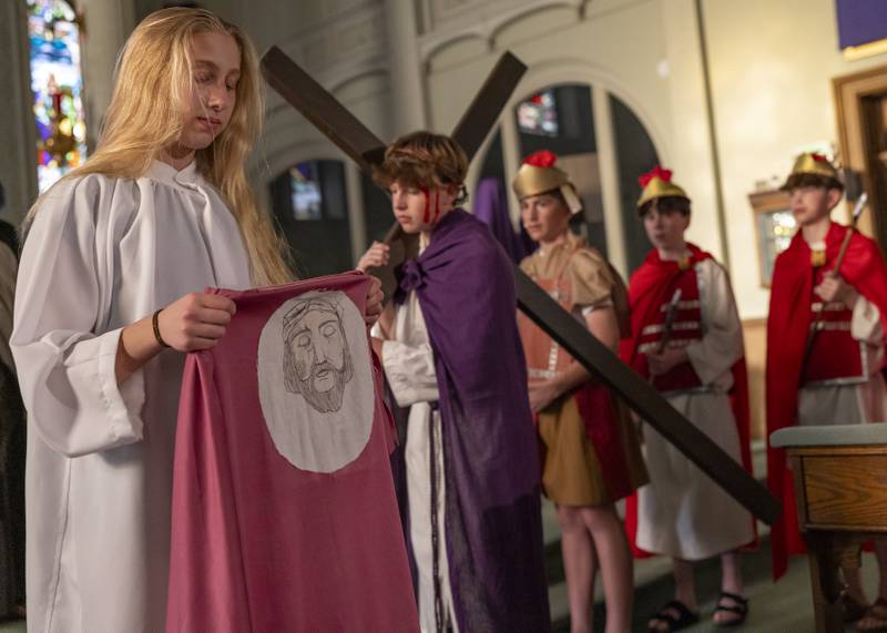 Aubrey Urbanski portraying Veronica holds up the veil that she used to wipe the face of Jesus during the Stations of The Cross event on April 16, 2025 at St. Patrick's Church.