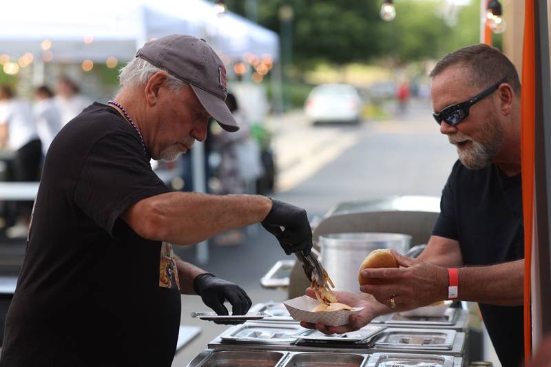 Jim Dodaro piles on grill onions for a customer at The Curator’s Cafe tent at the 6th Annual Joliet Blues Festival on Saturday, Aug. 10, 2024 at Bicentennial Park.