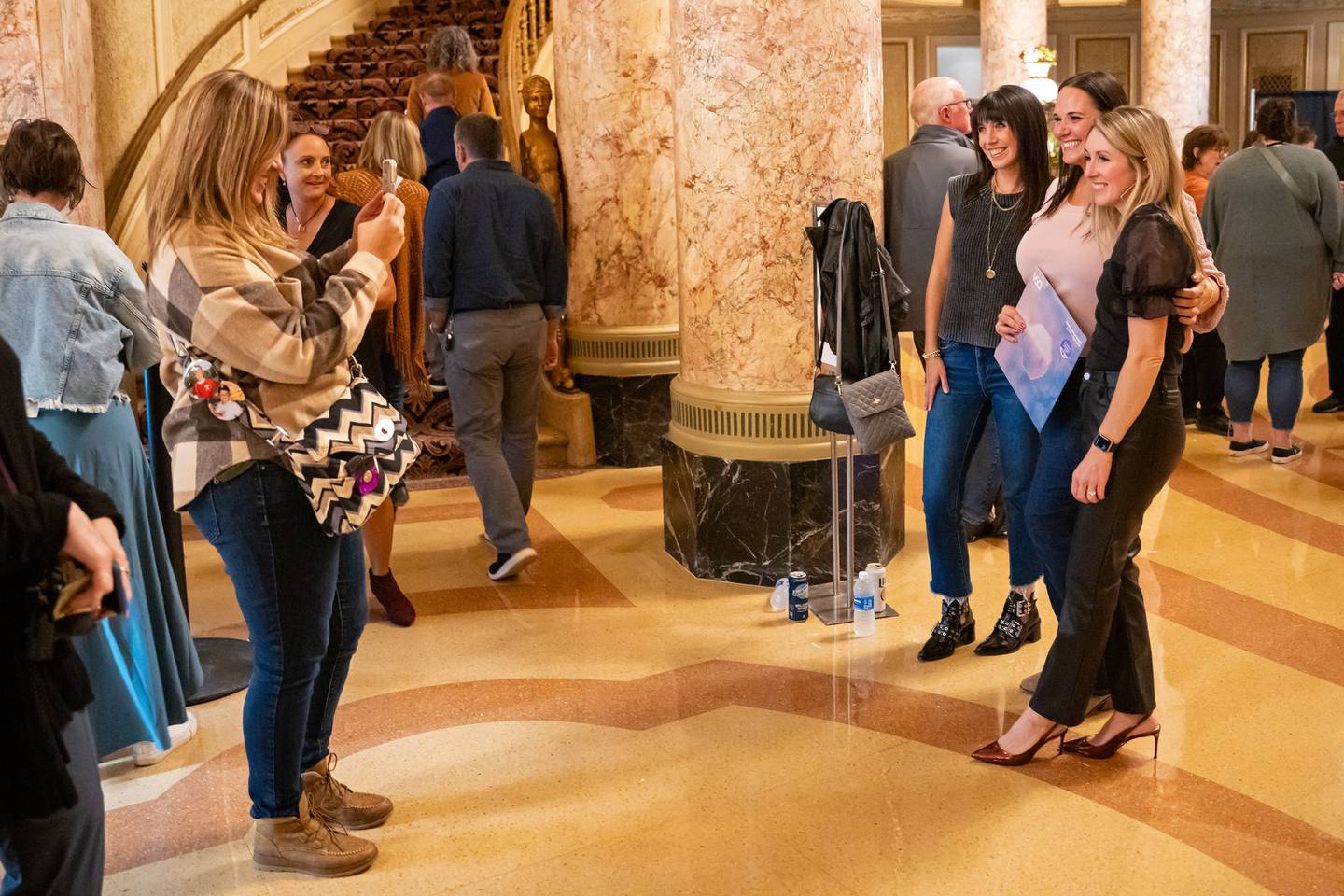 Concert attendees for the Vitamin String Quartet take photos in the lobby during the reopening of the Rialto Square Theatre in Joliet, Ill. on Tuesday Oct. 22, 2024