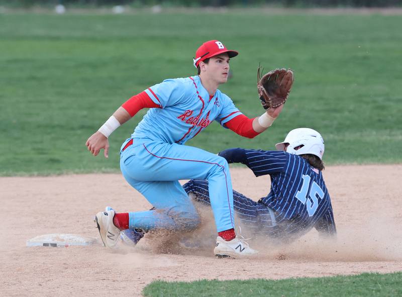 Benet's Luke Bafia (11) tries to throw out Nazareth's Cole Reifsteck (15) on a steal attempt during the varsity baseball game between Benet Academy and Nazareth Academy in La Grange Park on Monday, April 24, 2023.
