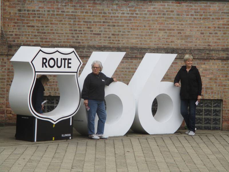 Red Carpet Corridor travelers pose for a photo before their journey at the Route 66 sculpture outside the Joliet Area Historical Museum on Saturday, May 6, 2023.