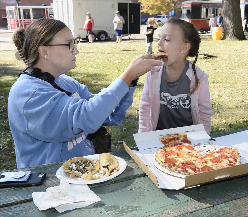 Sampling some of the food items Saturday, Sept. 24, 2022, from the Food Truck Festival at City Park in Streator, Allison Ainsley and her daughter Riley share some of their food with each other.