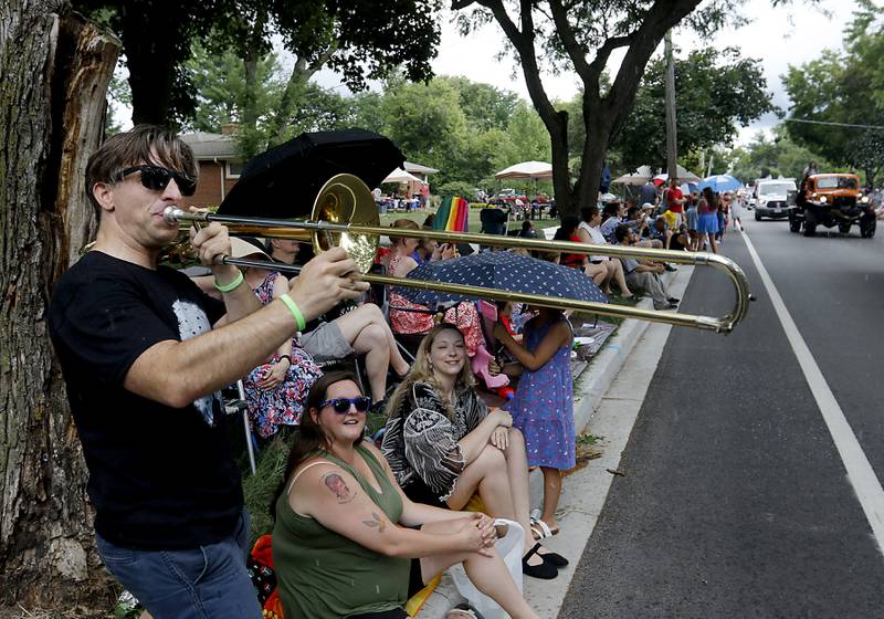 Adam Brown plays along with the Crystal Lake Strikers Drumline as they march by him on Sunday, July 6, 2024, during Crystal Lake’s annual Independence Day Parade on Dole Avenue in Crystal Lake.