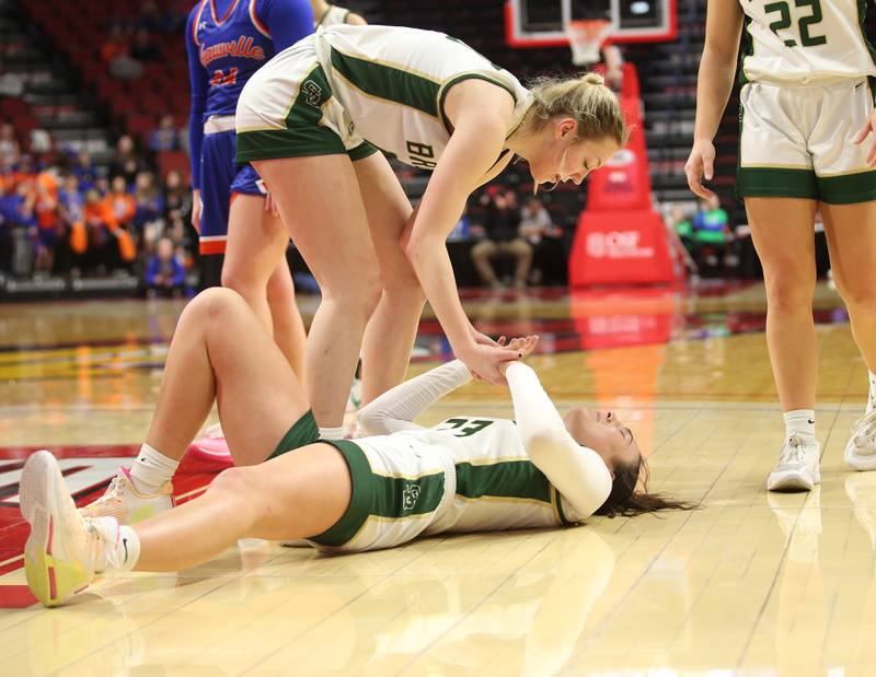 St. Bede's Ashlyn Ehm helps up teammate Ali Bosnich after hitting the floor on a drive to the hoop against Okawville during the Class 1A State semifinal game on Thursday, Feb. 29, 2024 at CEFCU Arena in Normal.