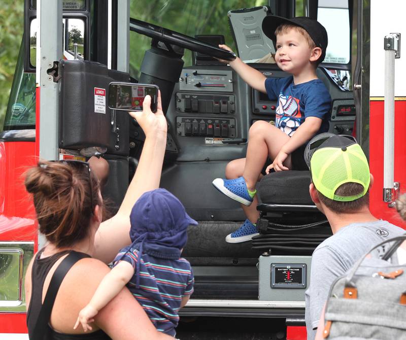 RJ Pepperman, 2, from Sycamore, takes his turn at the wheel of a DeKalb fire truck Thursday, July 21, 2022, during the DeKalb Chamber of Commerce Family Fun Fest at Hopkins Park in DeKalb.