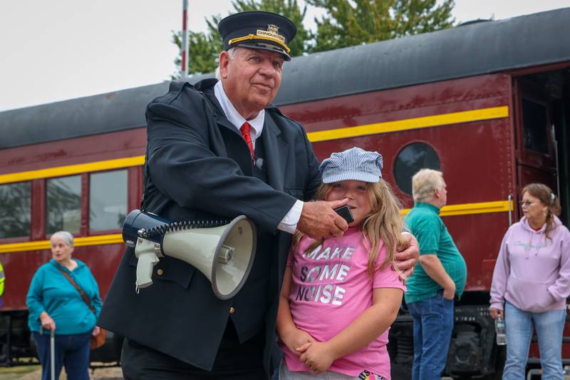 Child announces “All Aboard” to crowd on Saturday, September 28, 2024 at the railroad tracks in Bureau.