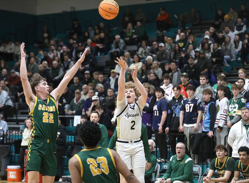 Sycamore's Logan Hodges (right) shoots the ball over Crystal Lake South's Nick Stowasser (left) and Crystal Lake South's David Mcfadden (center) during an IHSA Class 3A Woodstock North Sectional semifinal.basketball game on Wednesday, March 4, 2025, at Woodstock North High School.