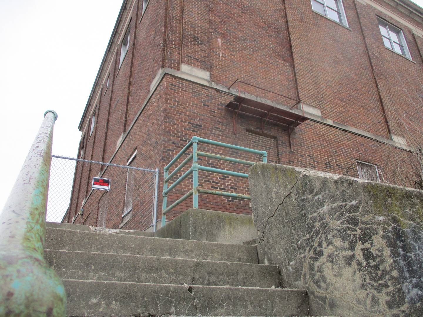 Security fence surrounds the old Joliet Catholic High School and cafeteria, a section of the building that stands at Jefferson and Hickory streets in Joliet, March 13, 2024.